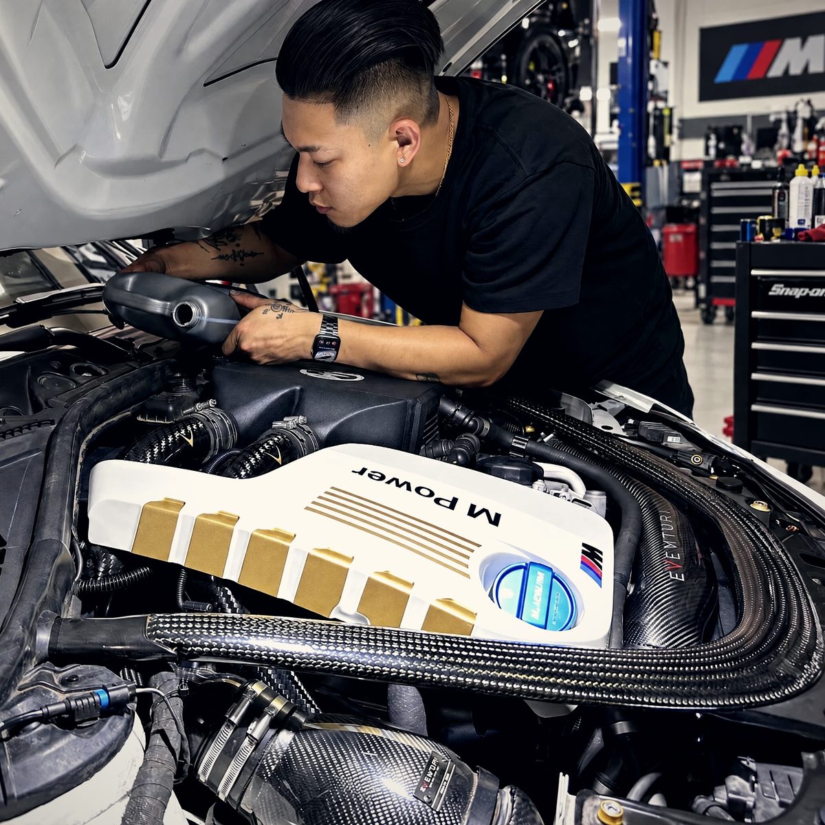 Work underway on a customer's modified BMW M3, carbon intake and charge piping in the open engine bay